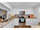 Modern kitchen featuring stainless steel appliances, granite countertops, and white cabinets for a sleek design at 4252 Sheldon Pl # 4252, New Port Richey, FL 34652