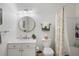 Bright bathroom featuring a single sink vanity with a round mirror and a shower-tub combo at 10764 70Th Ave # 1205, Seminole, FL 33772