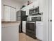 Modern kitchen features stainless steel appliances, white cabinets, granite counters and tile flooring at 10764 70Th Ave # 1205, Seminole, FL 33772