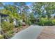 Lush landscaped backyard with paver walkway, mature trees, and concrete patio at 12116 N 52Nd St, Temple Terrace, FL 33617