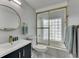 Bright bathroom with gold hardware, a bathtub, glass block, and marble floors at 12116 N 52Nd St, Temple Terrace, FL 33617