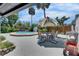 Outdoor area with a pool, covered dining and seating, and lush landscaping at 12116 N 52Nd St, Temple Terrace, FL 33617