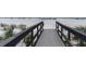 Close-up view of a wooden boardwalk with railings leading to the beach and ocean at 12274 1St W St # 2, Treasure Island, FL 33706
