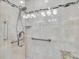 Shower featuring safety grab bars, hand-held shower head, glass enclosure, and tiled seat at 12274 1St W St # 2, Treasure Island, FL 33706