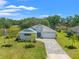 Lovely home featuring lush landscaping, a brick driveway, and a sprawling green lawn with mature trees at 12546 Wildebeest Way, Spring Hill, FL 34610