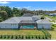 Back aerial view featuring screened pool, fenced yard, and mature trees at 12546 Wildebeest Way, Spring Hill, FL 34610