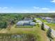 Aerial view of a beautiful home, surrounded by mature trees and a pond at 12546 Wildebeest Way, Spring Hill, FL 34610