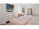 Comfortable bedroom featuring a dresser with TV, a desk, and a window at 12546 Wildebeest Way, Spring Hill, FL 34610