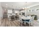 Open-concept kitchen and dining area with white furniture, pendant lighting, and natural light at 12546 Wildebeest Way, Spring Hill, FL 34610