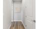 Hallway with wood-look flooring and neutral paint, enhanced by decorative art at 12546 Wildebeest Way, Spring Hill, FL 34610