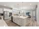 Bright, open kitchen with an island, pendant lighting, stainless steel appliances, and a view of the living area at 12546 Wildebeest Way, Spring Hill, FL 34610