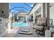 Inviting outdoor patio area with a cozy seating area, dining set, and view of the screened pool at 12546 Wildebeest Way, Spring Hill, FL 34610
