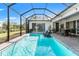 Refreshing screened-in pool area with lounge chairs, dining set, and lush backyard scenery at 12546 Wildebeest Way, Spring Hill, FL 34610