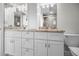 Contemporary bathroom featuring dual vanities with granite counters, white cabinetry, and modern fixtures at 1270 Gulf Blvd # 501, Clearwater Beach, FL 33767