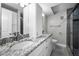 Modern bathroom featuring dual sinks with granite countertops, white cabinets, and a glass-enclosed shower at 1270 Gulf Blvd # 501, Clearwater Beach, FL 33767