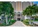 Inviting walkway to a high rise building's entrance, lined with mature tropical landscaping at 1270 Gulf Blvd # 501, Clearwater Beach, FL 33767