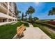 Scenic view featuring a wooden bench, lush landscaping, and community grounds at 1270 Gulf Blvd # 501, Clearwater Beach, FL 33767