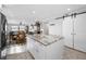 Bright kitchen with island, sliding barn door and views to dining area and living room at 1270 Gulf Blvd # 501, Clearwater Beach, FL 33767