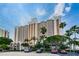 Exterior view of a high rise building with on-site parking and mature tropical trees at 1270 Gulf Blvd # 501, Clearwater Beach, FL 33767