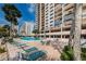 Outdoor pool area featuring lounge chairs, tables, and tropical landscaping at 1270 Gulf Blvd # 501, Clearwater Beach, FL 33767