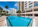 Exterior community pool, surrounded by lush landscaping and seating at 1270 Gulf Blvd # 501, Clearwater Beach, FL 33767
