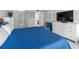 Spacious bedroom with a large bed, white dresser, and view to a small blue loveseat at 1430 Gulf Blvd # 102, Clearwater Beach, FL 33767