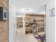 Hallway with wood-paneled walls, tile floors, decorative art, and a heron sculpture on a glass table at 1430 Gulf Blvd # 102, Clearwater Beach, FL 33767