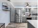 Bright kitchen with stainless steel refrigerator, gray cabinets, and a stylish wine rack at 1430 Gulf Blvd # 102, Clearwater Beach, FL 33767