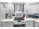 Close-up of modern kitchen with stainless steel stove and appliances, and gray cabinetry at 1430 Gulf Blvd # 102, Clearwater Beach, FL 33767