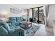 Comfortable living room with a blue sectional sofa and sliding glass doors to the balcony at 1430 Gulf Blvd # 102, Clearwater Beach, FL 33767