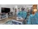 Cozy living room featuring a blue sofa, stylish decor, and an open layout with a kitchen view at 1430 Gulf Blvd # 102, Clearwater Beach, FL 33767