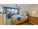 Bright bedroom features a ceiling fan, balcony access, and water views at 1460 Gulf Blvd # 406, Clearwater Beach, FL 33767