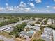 Wide aerial view showcasing a residential area with a community pool, parking, and green landscaping under a cloudy sky at 1655 S Highland Ave # D140, Clearwater, FL 33756