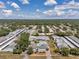 Panoramic aerial view of a residential community featuring a central pool and well-maintained grounds under a blue sky at 1655 S Highland Ave # D140, Clearwater, FL 33756