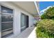 Exterior view of the white condo building with sliding glass doors and walkways at 1655 S Highland Ave # D140, Clearwater, FL 33756
