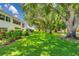 Lush lawn and trees on the side of the condo building exterior on a sunny day at 1655 S Highland Ave # D140, Clearwater, FL 33756