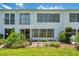 White condo building exterior with a lawn, garden and balcony on a sunny day at 1655 S Highland Ave # D140, Clearwater, FL 33756