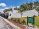 Exterior view of the property with parking spots and sign with the name of the community and address at 1655 S Highland Ave # D140, Clearwater, FL 33756