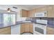 Galley-style kitchen featuring bright cabinets, updated appliances, and tile flooring at 1655 S Highland Ave # D140, Clearwater, FL 33756