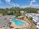 Aerial shot of a kidney-shaped pool surrounded by lounge chairs and tables within a fenced community area at 1655 S Highland Ave # D140, Clearwater, FL 33756