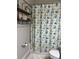 Bathroom featuring a decorative shower curtain and decorative shelving for storage creating a stylish space at 16840 Whisper Elm St, Wimauma, FL 33598