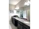 Bathroom featuring a granite countertop, double sinks, and a view into the bedroom at 16840 Whisper Elm St, Wimauma, FL 33598