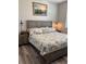 Cozy bedroom featuring a king-size bed with nautical-themed bedding, two nightstands, and luxury vinyl flooring at 16840 Whisper Elm St, Wimauma, FL 33598
