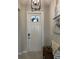 Well-lit foyer with a white front door, a small bench, a decorative light fixture, and a coastal themed art at 16840 Whisper Elm St, Wimauma, FL 33598