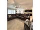 Spacious living room featuring tile flooring, sofa, and a seamless flow to the kitchen at 16840 Whisper Elm St, Wimauma, FL 33598