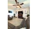 Inviting living room with a cozy fireplace, ceiling fan, and tile flooring throughout at 16840 Whisper Elm St, Wimauma, FL 33598