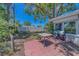 A backyard patio with pavers, chairs, and view of the fenced in yard with mature trees at 1710 S Lake Ave, Clearwater, FL 33756