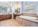 Bathroom featuring a large soaking tub with a tile surround, double vanity and a makeup table at 19708 Wellington Manor Blvd, Lutz, FL 33549
