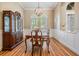 Formal dining room with hardwood floors, classic china cabinet, and wainscoting at 19708 Wellington Manor Blvd, Lutz, FL 33549