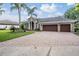 A charming single-story home with a paved driveway, a three-car garage and lush landscaping at 19708 Wellington Manor Blvd, Lutz, FL 33549